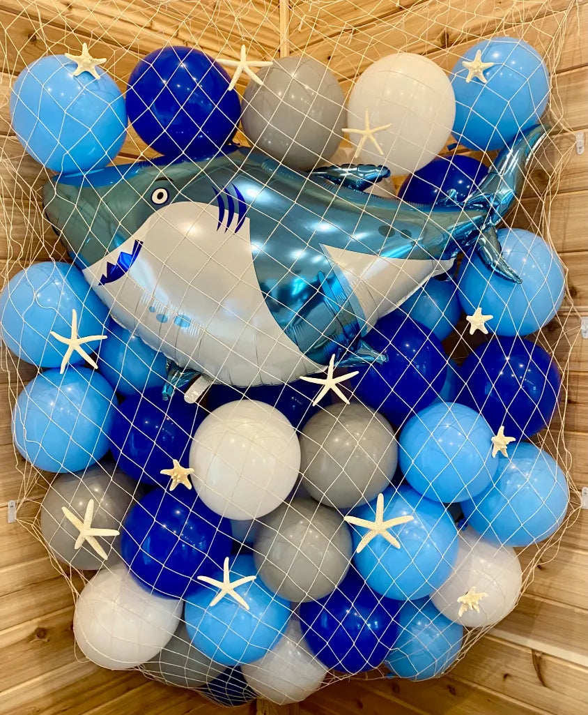 blue silver and white balloons caught in a net