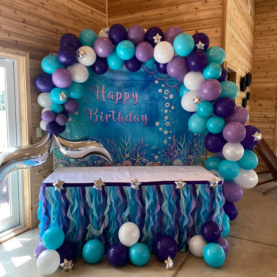 blue purple and white balloons over happy birthday party table
