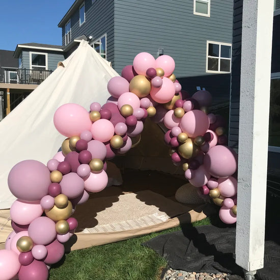 punk and gold balloons set up as entrance to a tent