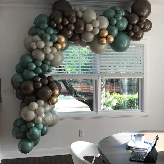 green silver and black balloons over window indoors