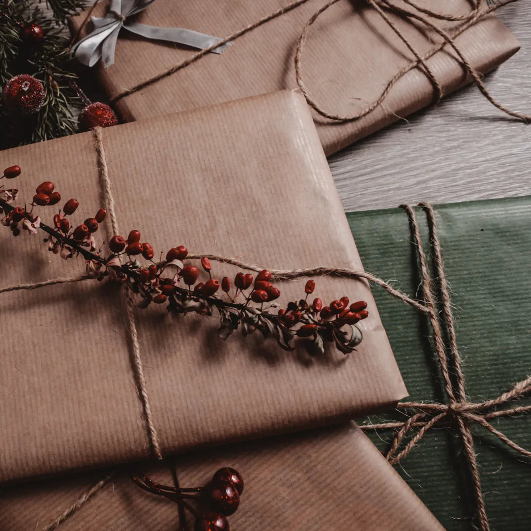 brown gifts wrapped with twine and red botanicals